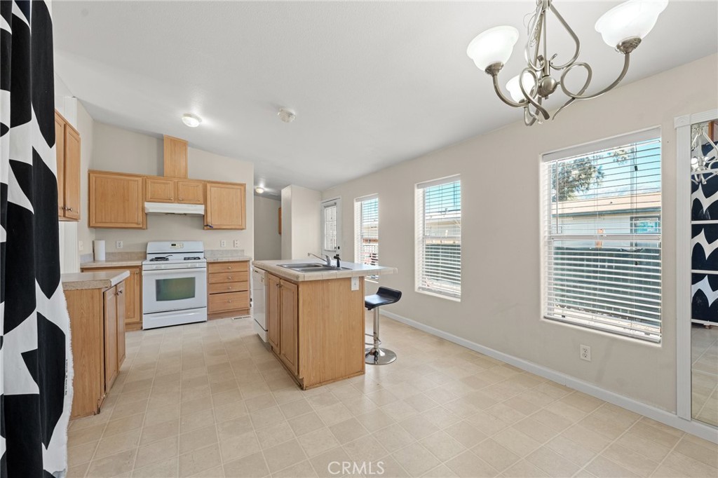 52076 Maxine Avenue Cabazon, CA 92230 - Photo 10 of 35 a kitchen with a refrigerator a stove top oven a sink dishwasher and wooden cabinets