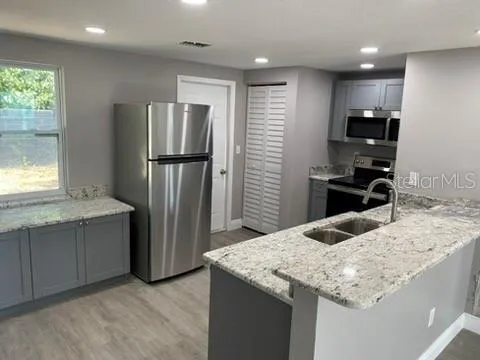 a view of a kitchen with a sink and wooden floor