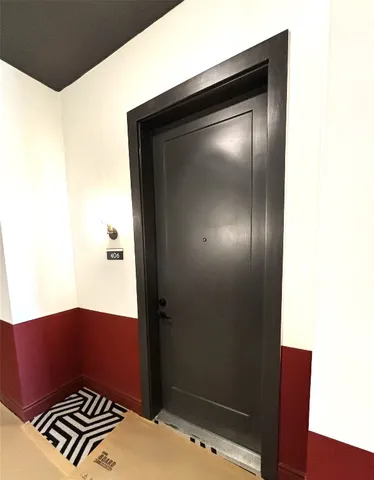 a view of hallway with stainless steel appliances wooden floor and staircase