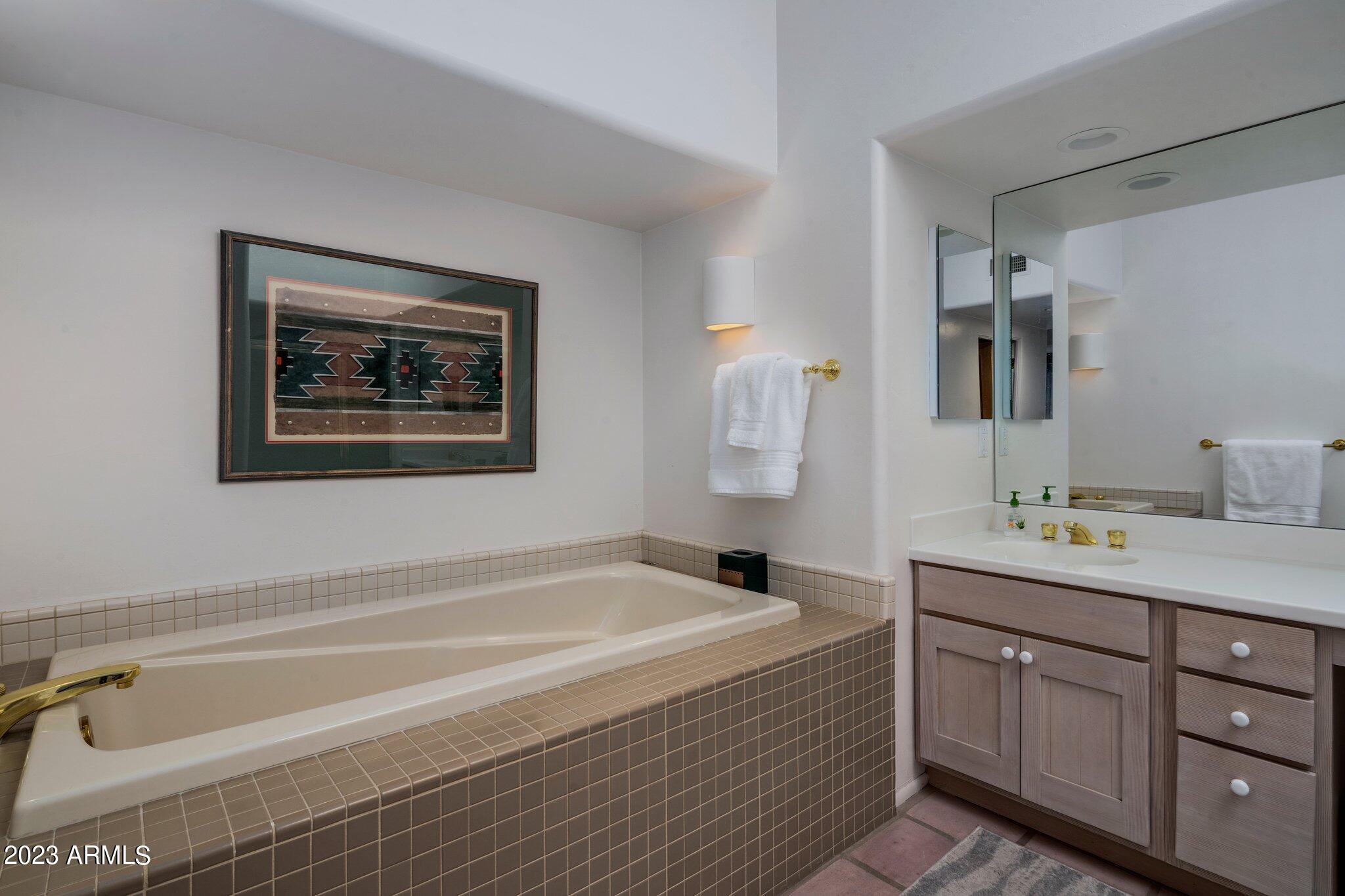 10111 East Graythorn Drive Scottsdale, AZ 85262 - Photo 9 of 14 a spacious bathroom with a tub sink and mirror
