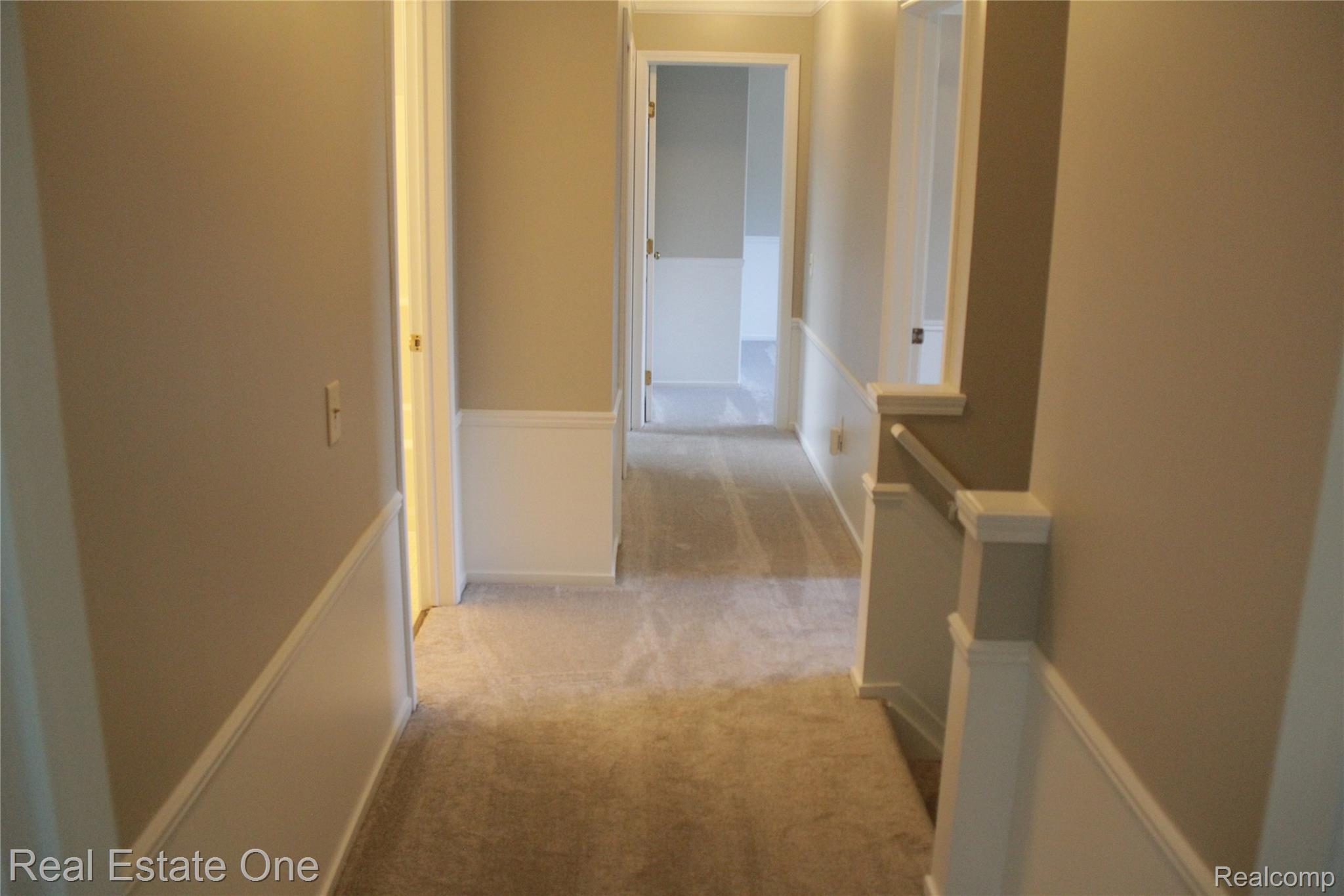 44777 Saltz Road Canton, MI 48187 - Photo 44 of 65 Hallway featuring light-toned carpet, neutral wall paint, white wainscoting, and white trim