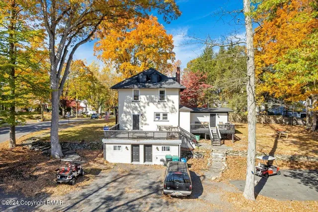 a view of a small house with roof deck and furniture