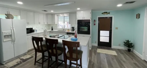 a kitchen with stainless steel appliances a sink a table and chairs