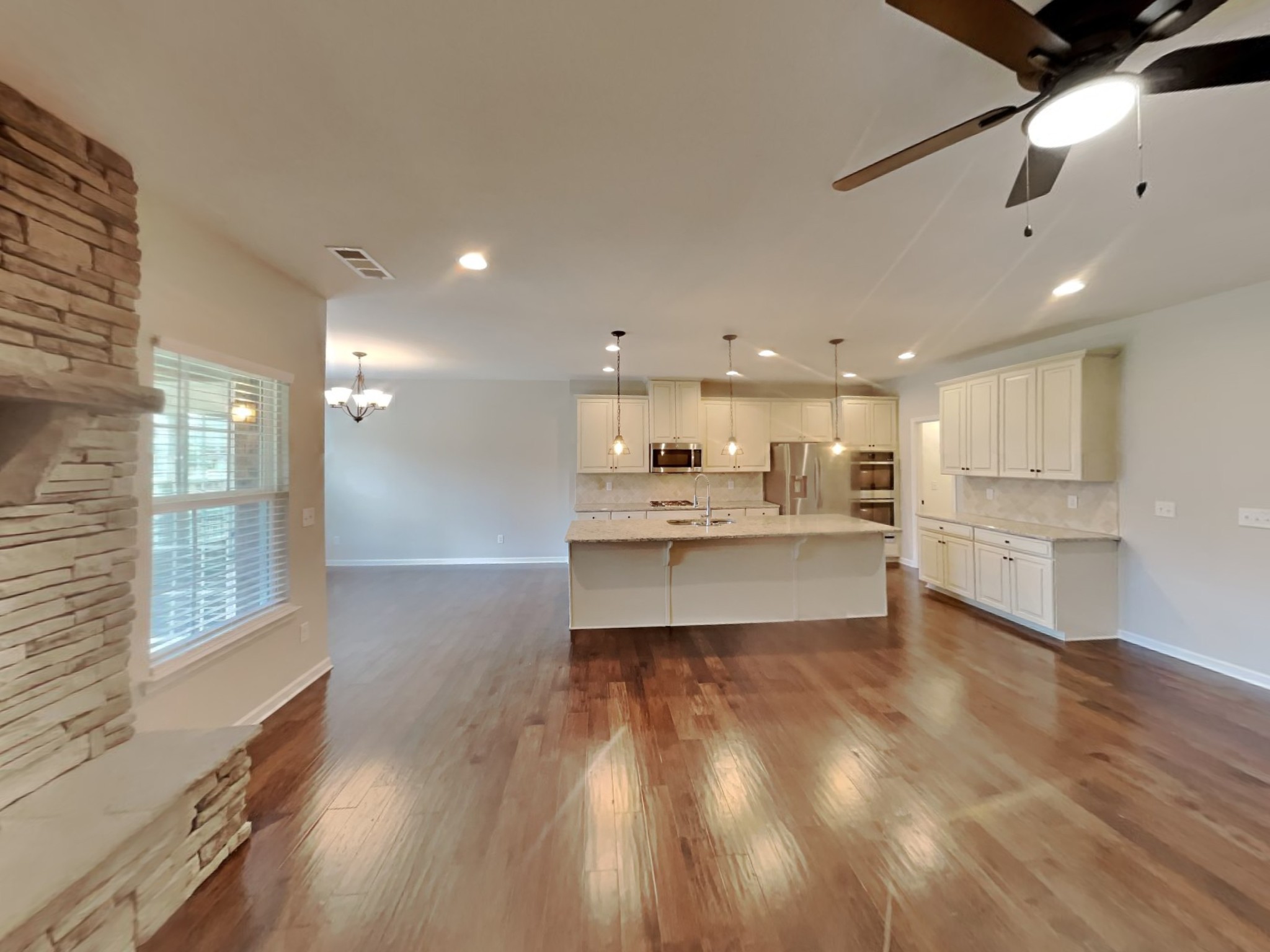 132 Hackney Lane Gallatin, TN 37066 - Photo 3 of 23 a large kitchen with kitchen island a stove a sink dishwasher and white cabinets with wooden floor