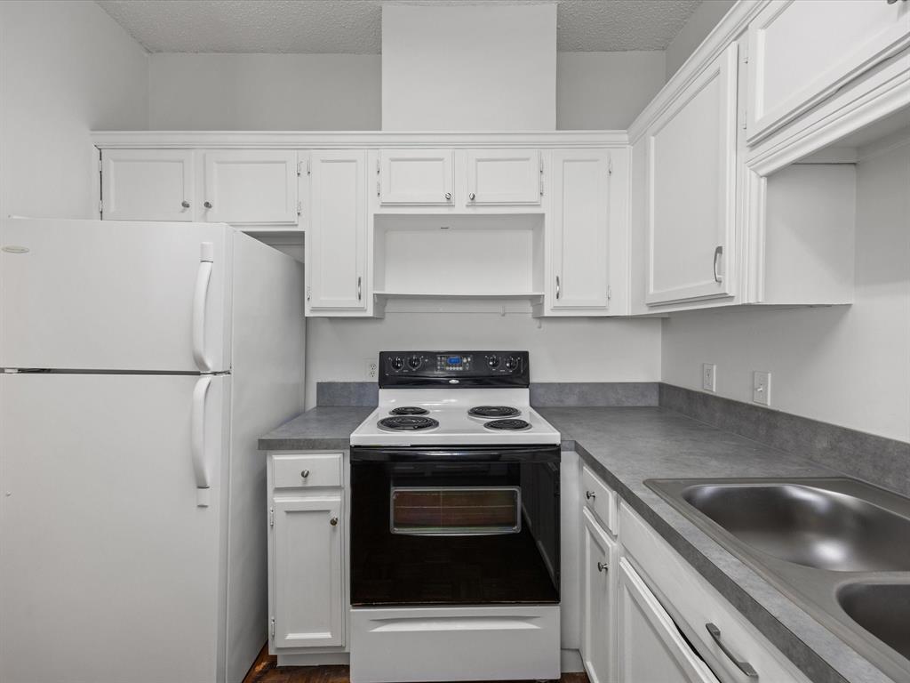 5310 Keller Springs Road, Unit 332 Dallas, TX 75248 - Photo 7 of 38 a kitchen with refrigerator a stove a sink and cabinets