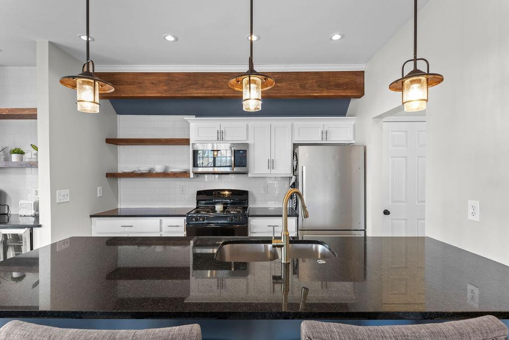 21 B Edinburgh Street Valparaiso, IN 46385 - Photo 5 of 17 a kitchen with kitchen island stainless steel appliances a stove a refrigerator and chairs