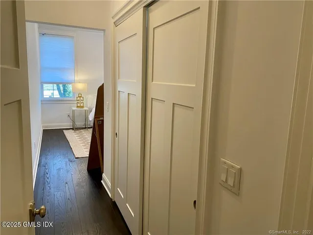 a view of a hallway with wooden floor and a cabinet