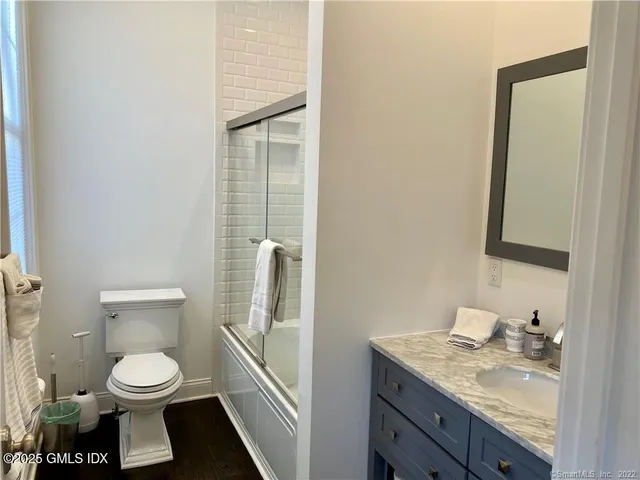 a bathroom with a granite countertop toilet and a sink