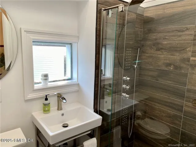 a bathroom with a sink mirror and shower
