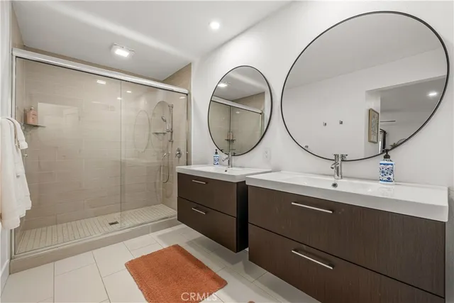 a bathroom with a double vanity sink mirror and shower