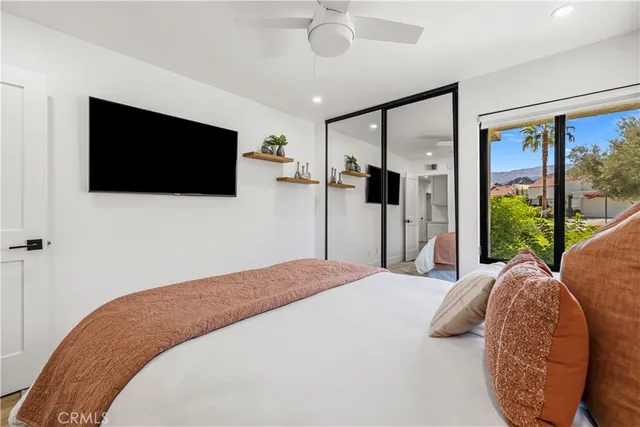 a bedroom with a bed window and a flat screen tv