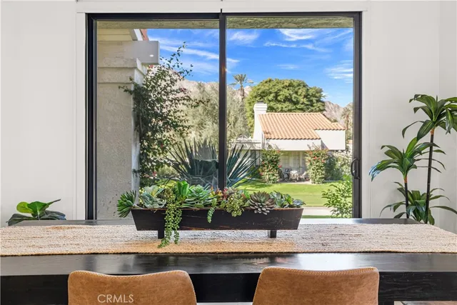 a vase of flowers sitting on a table with a potted plant