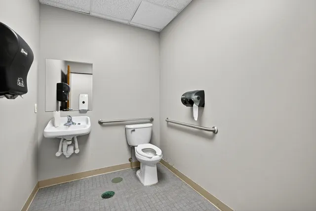 a bathroom with a toilet sink and mirror