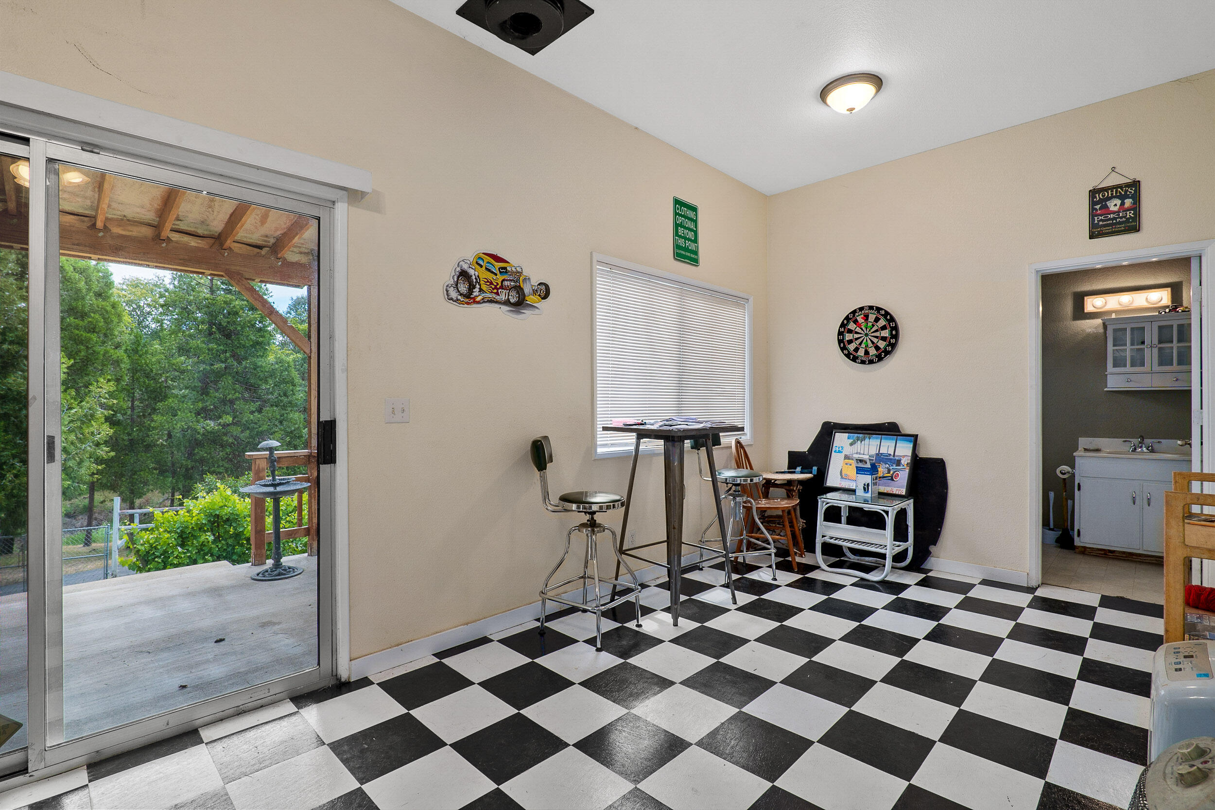 6801 Tunnel Loop Road Grants Pass, OR 97526 - Photo 28 of 40 a living room with a black white checkered floor with a gaming machine and dining chair