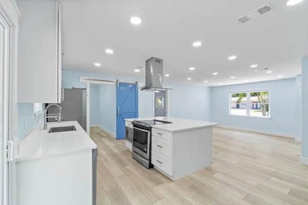 a kitchen with stainless steel appliances granite countertop a sink a stove a refrigerator and a microwave
