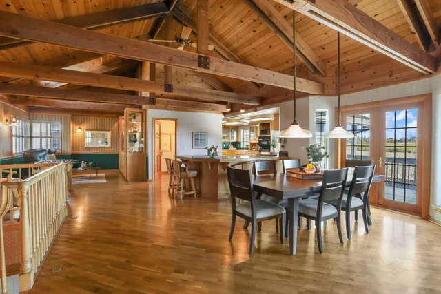 a dining hall with stainless steel appliances granite countertop a stove and cabinets with wooden floor