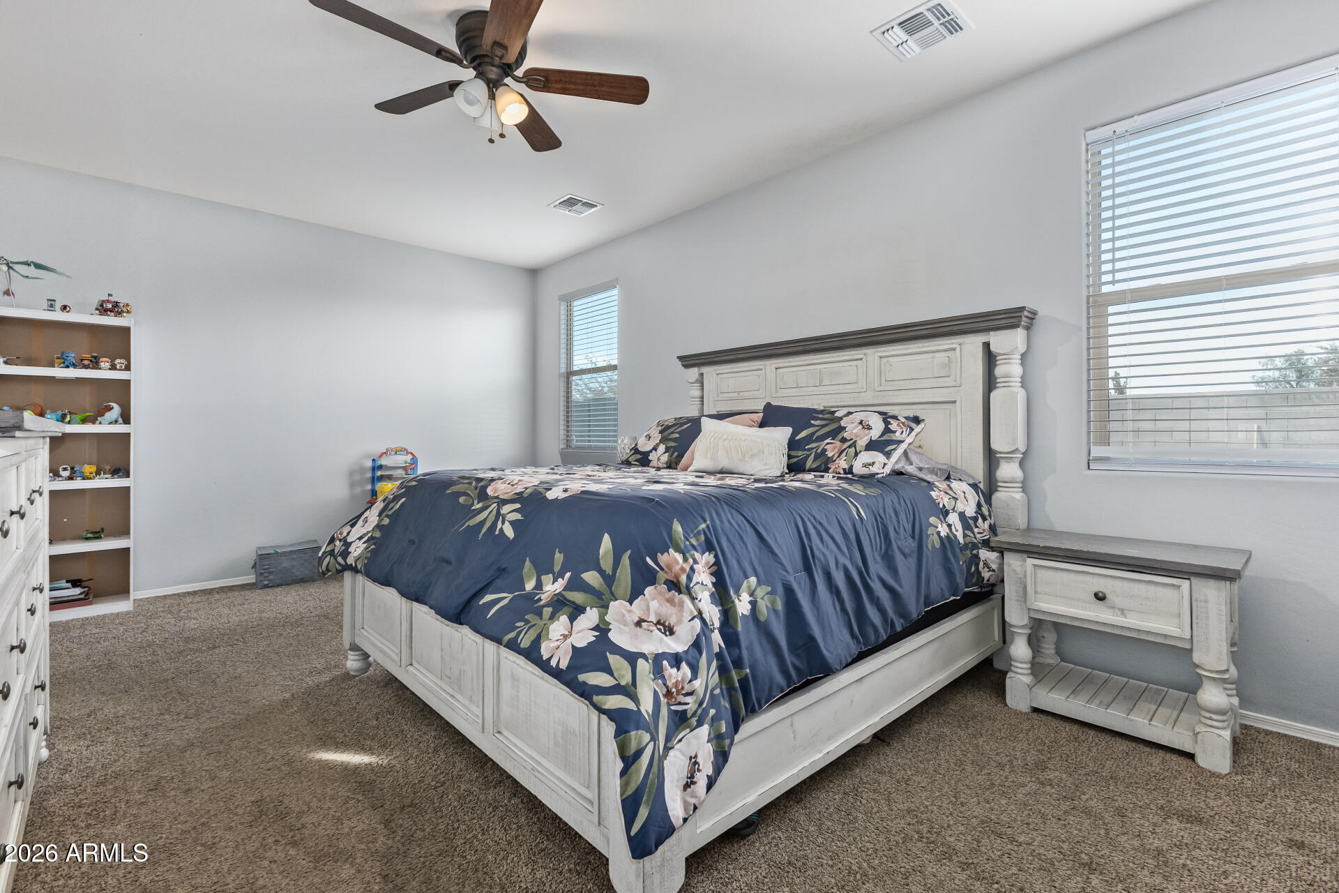 10326 West Payson Road Tolleson, AZ 85353 - Photo 13 of 27 a bed sitting in a bedroom next to a window and a chandelier