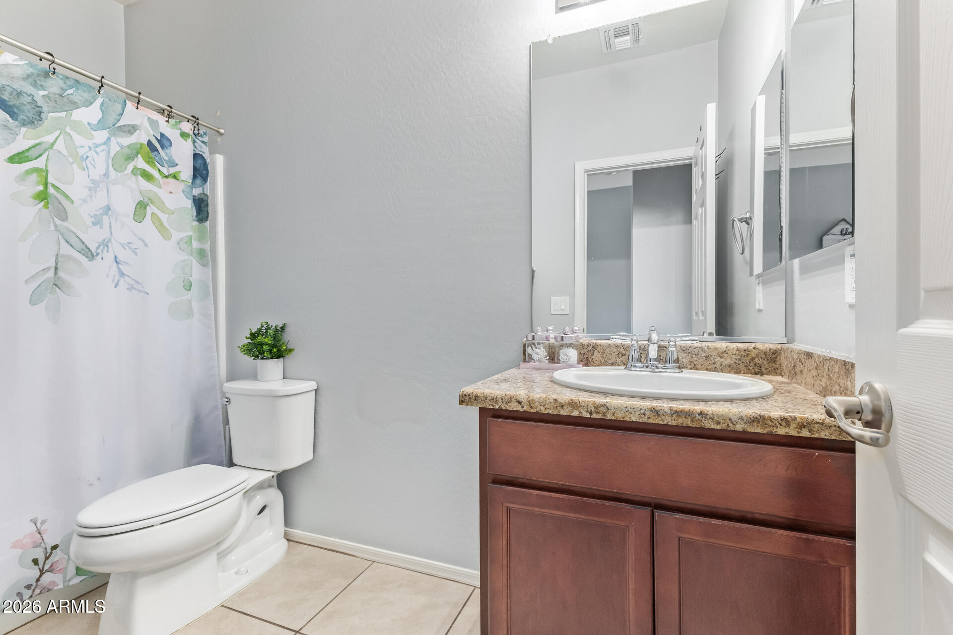 10326 West Payson Road Tolleson, AZ 85353 - Photo 19 of 27 a bathroom with a granite countertop sink a toilet and a mirror