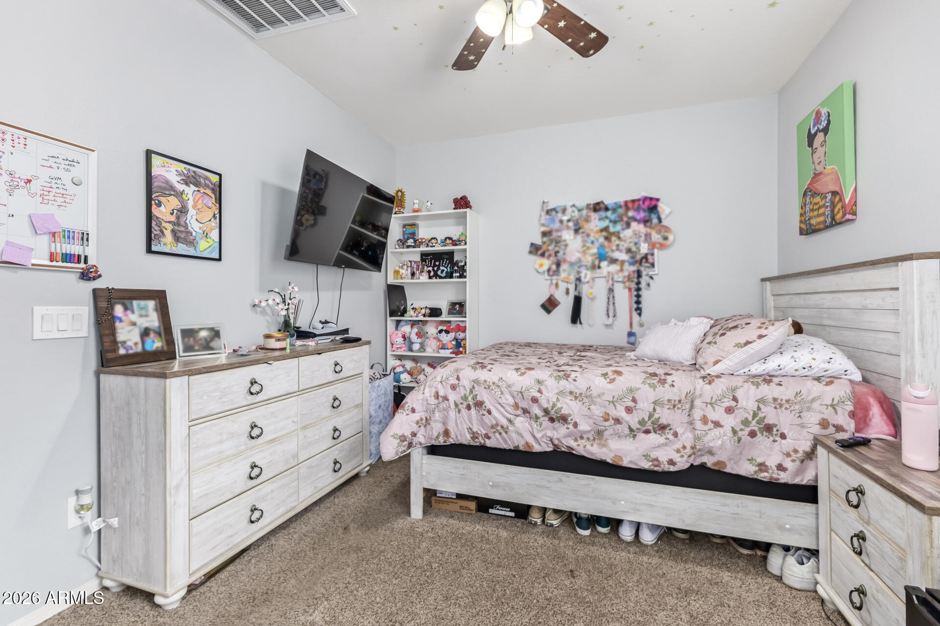 10326 West Payson Road Tolleson, AZ 85353 - Photo 21 of 27 a bedroom with a bed and a flat screen tv in a dresser