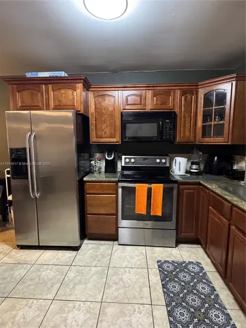 a kitchen with stainless steel appliances granite countertop a refrigerator and a stove