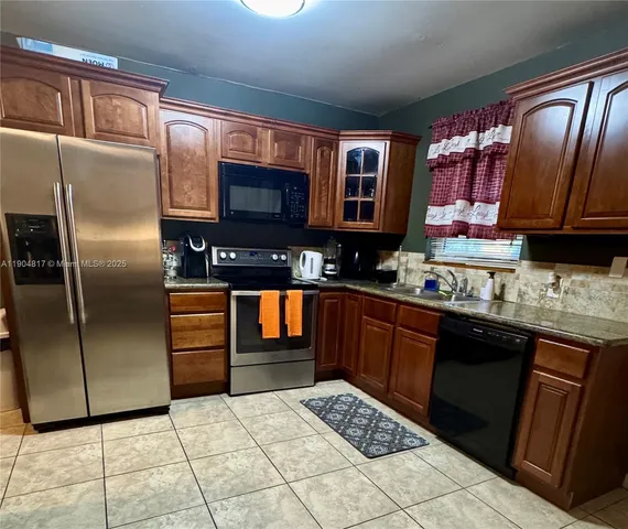 a kitchen with stainless steel appliances granite countertop a refrigerator and a stove top oven