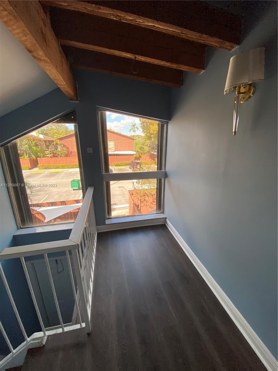 6934 Southwest 114th Place, Unit F55 Miami, FL 33173 - Photo 2 of 10 a view of an empty room with wooden floor and a window