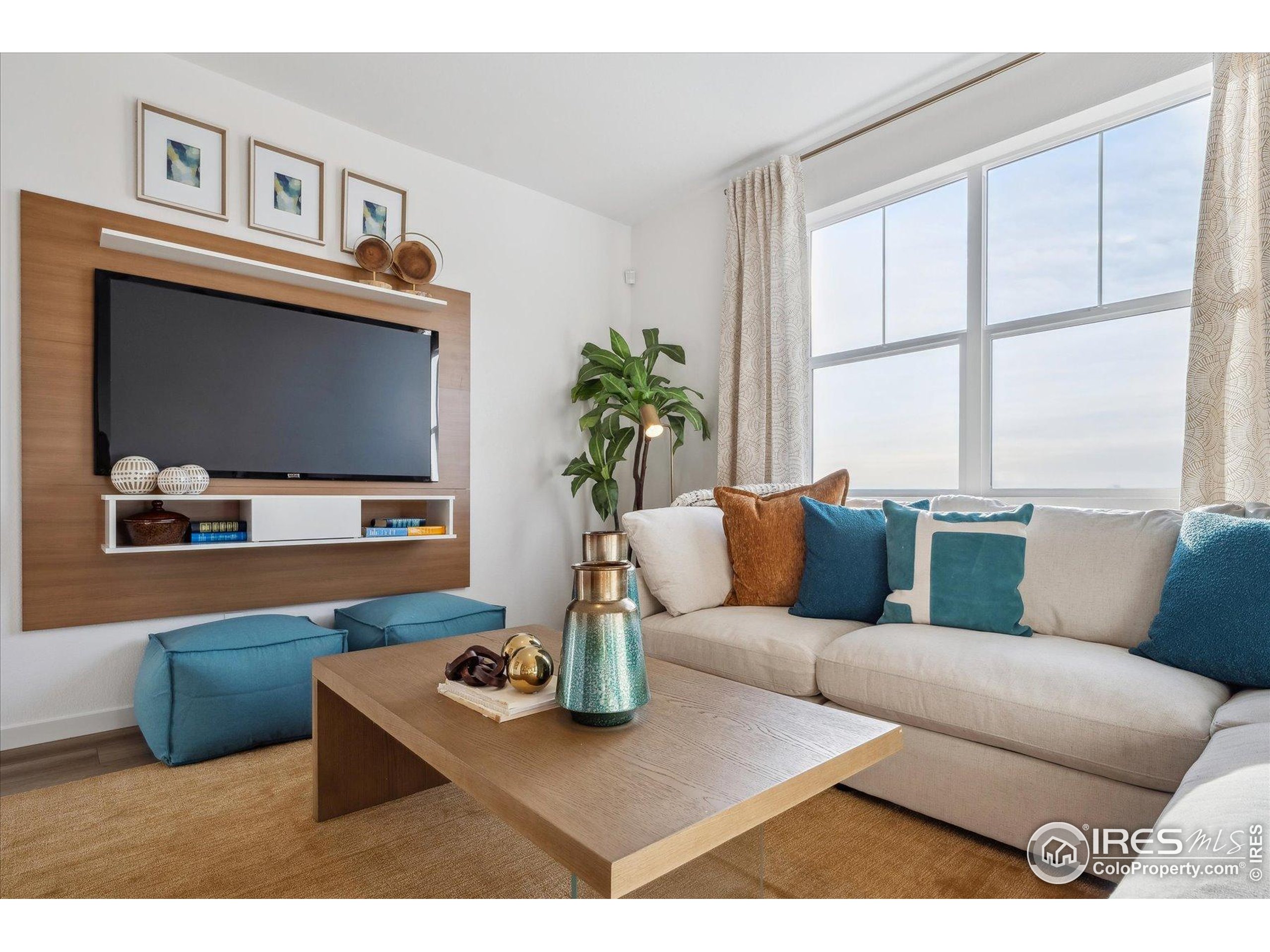 2207 Crosswind Street Fort Lupton, CO 80621 - Photo 13 of 26 a living room with furniture a flat screen tv and a large window