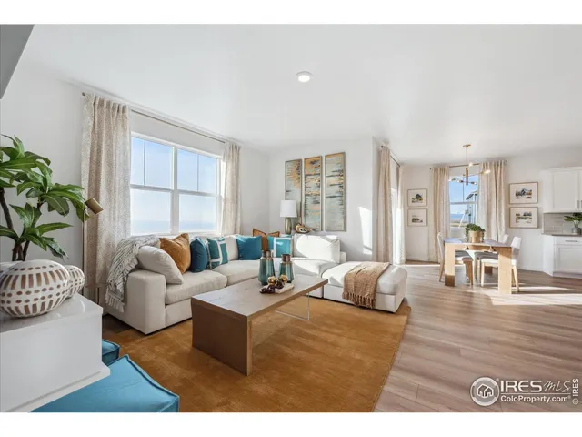 a living room with furniture potted plant and a large window
