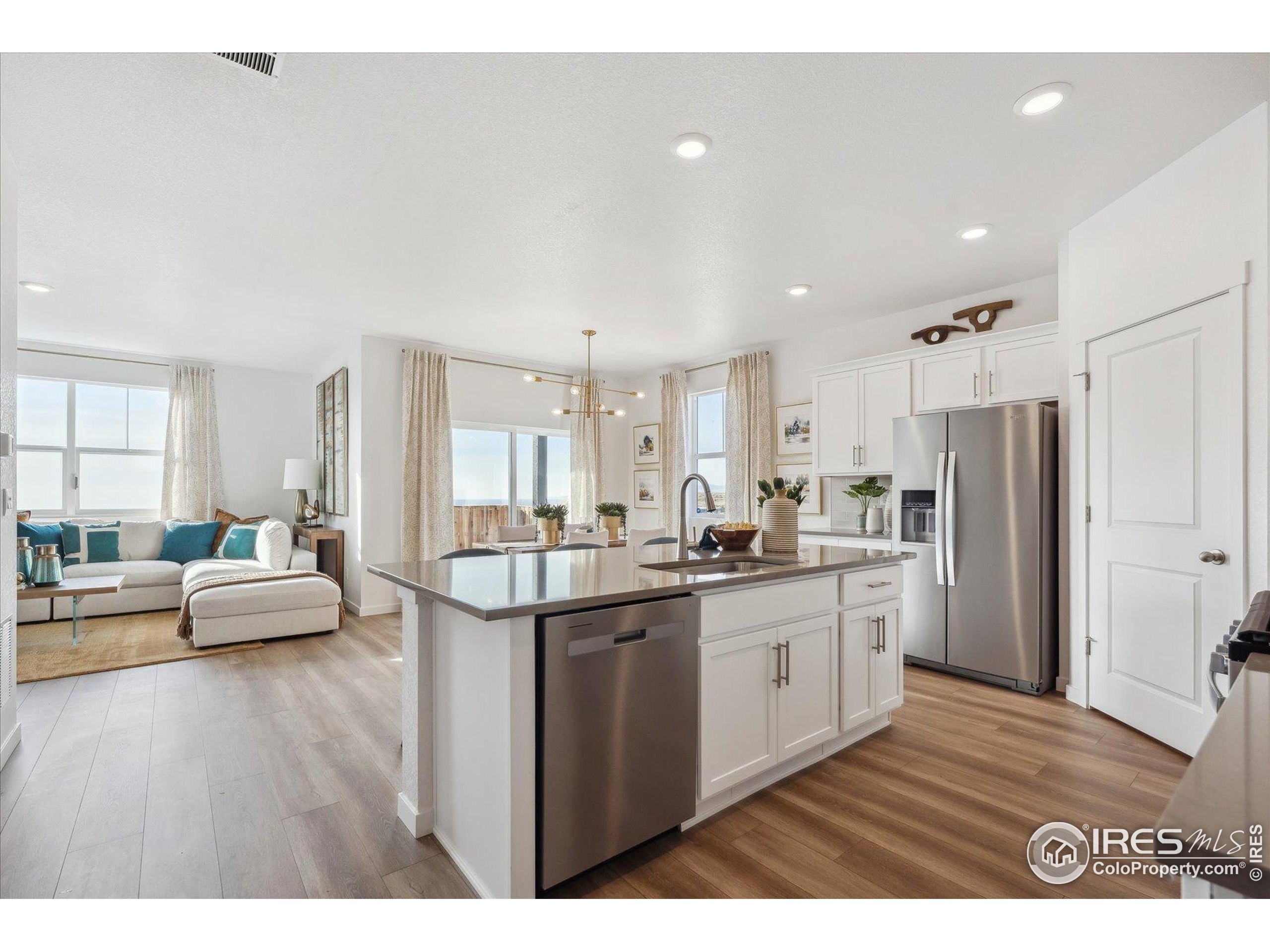 2207 Crosswind Street Fort Lupton, CO 80621 - Photo 5 of 26 a kitchen with stainless steel appliances granite countertop a lot of counter space and wooden floor