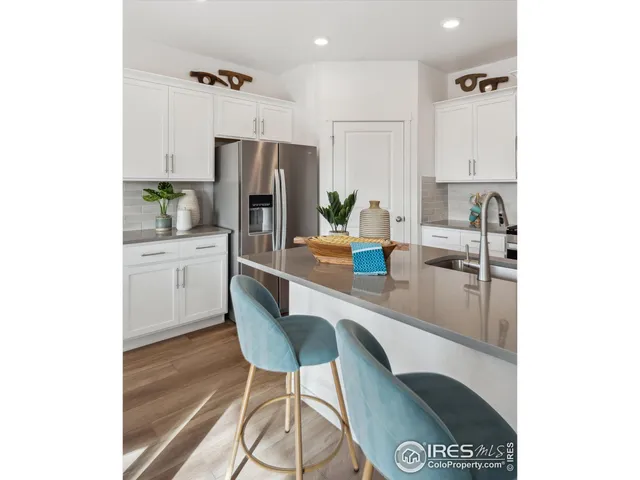 a kitchen with a table chairs refrigerator and microwave