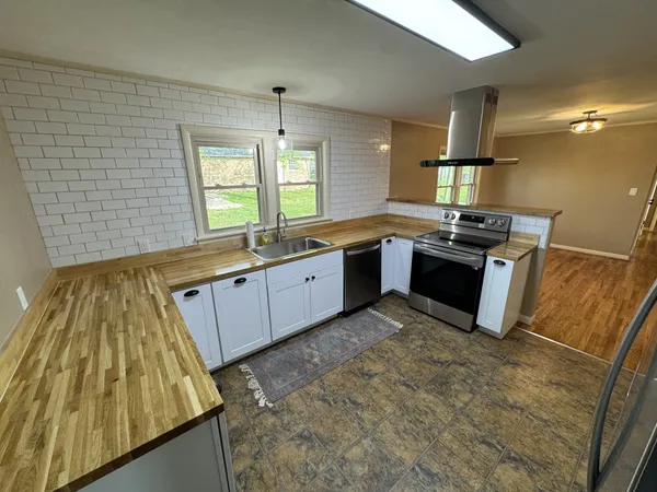 a large kitchen with wooden cabinets and a stove
