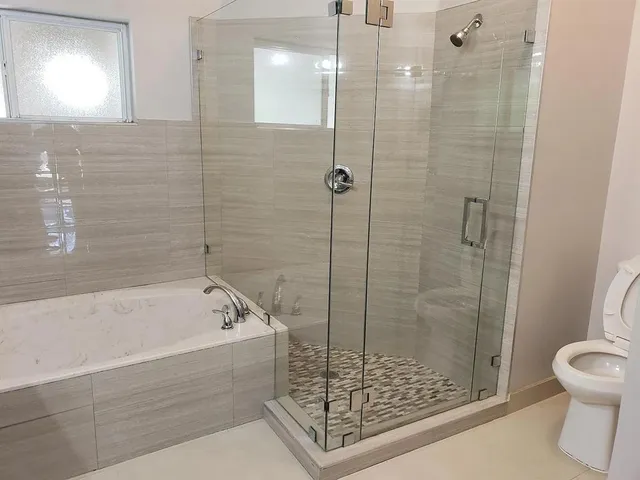 a bathroom with a granite countertop sink a mirror and a bathtub