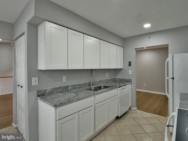 a kitchen with white cabinets and white appliances