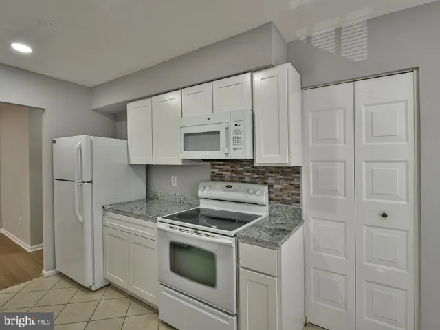 a stove top oven sitting inside of a kitchen