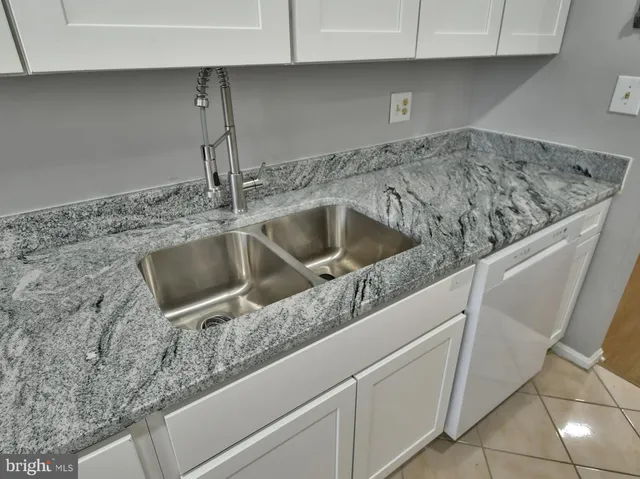 a view of a hallway with wooden floor and a bathroom