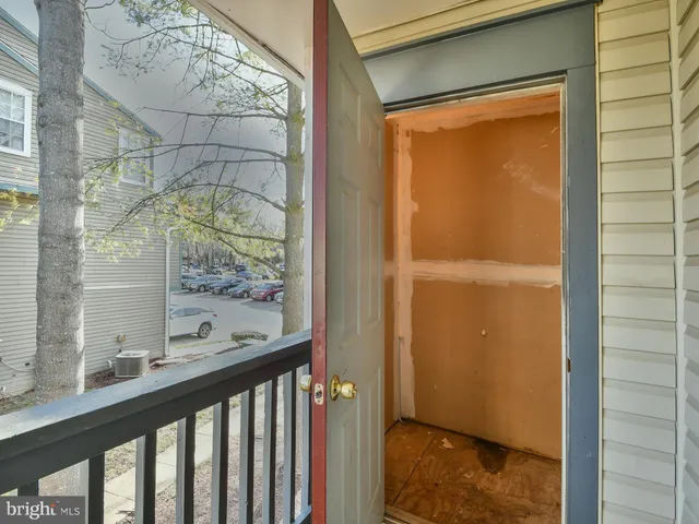 a view of a balcony with two windows and wooden fence