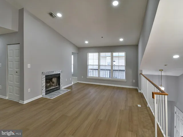 an empty room with wooden floor and a fireplace