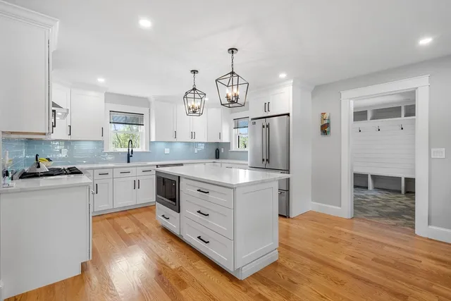 a kitchen with white cabinets stainless steel appliances and a window