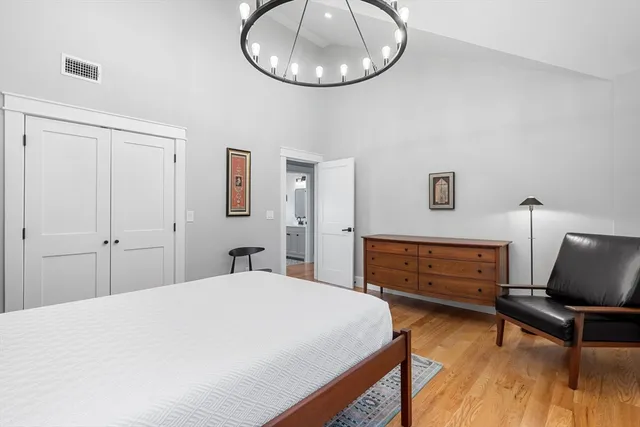 a bedroom with a bed and a chandelier