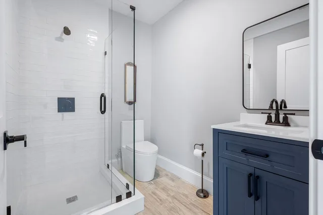 a bathroom with a granite countertop sink a toilet and shower