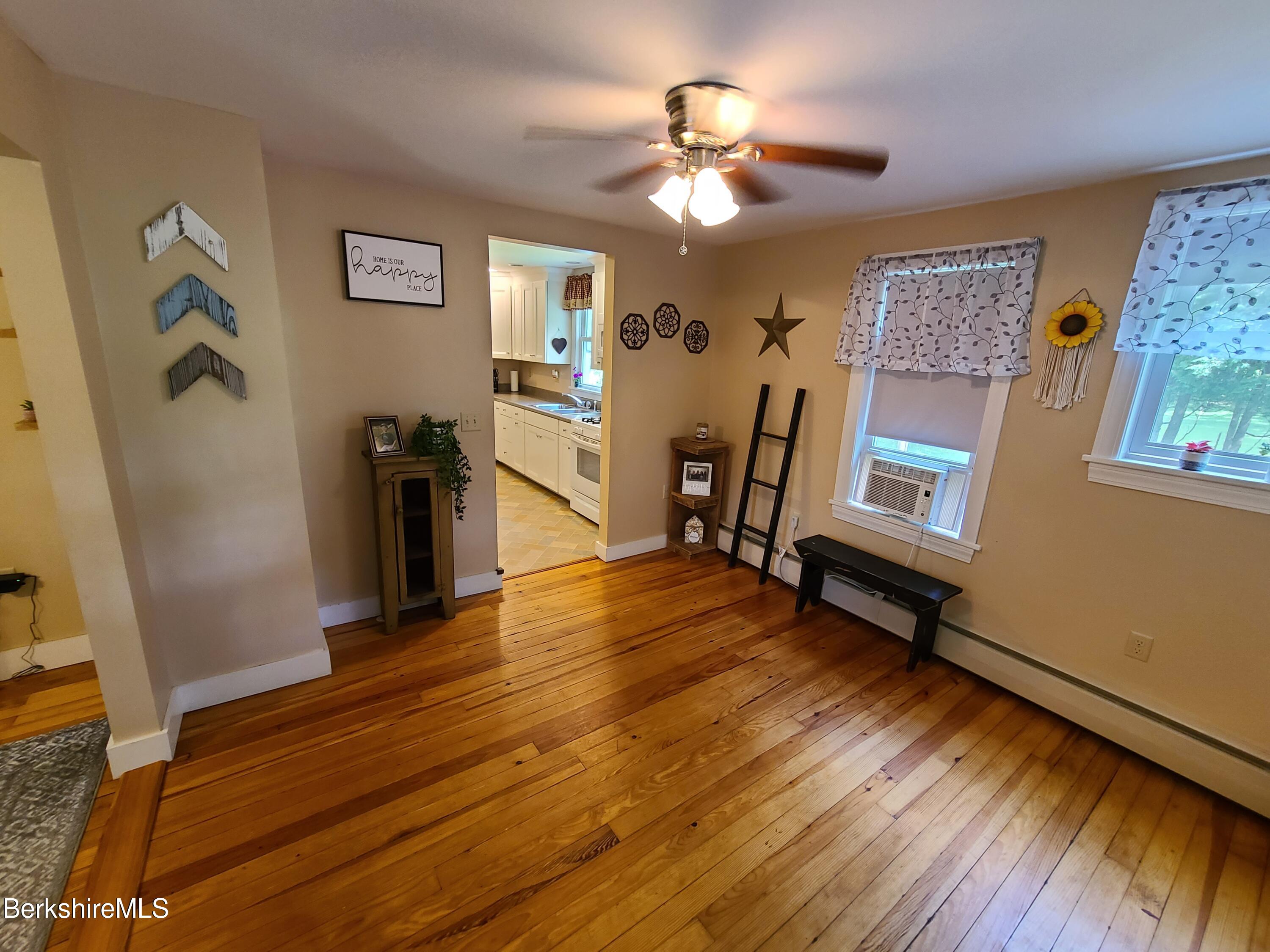 164 Cross Road Clarksburg, MA 01247 - Photo 3 of 22 a view of a livingroom with furniture a ceiling fan and wooden floor