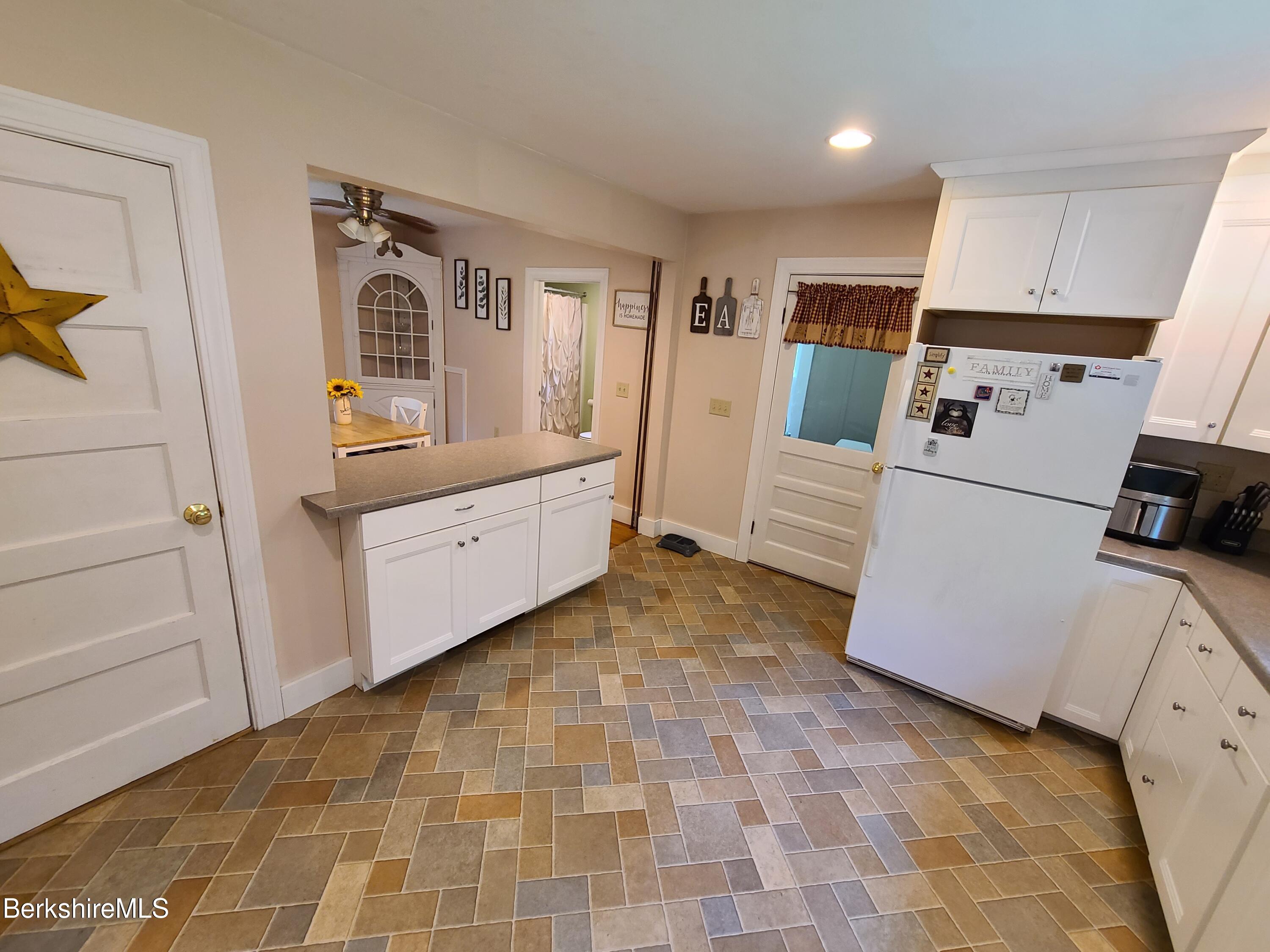 164 Cross Road Clarksburg, MA 01247 - Photo 5 of 22 a kitchen with a refrigerator and white cabinets