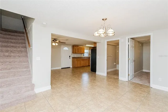 an empty room with kitchen and windows