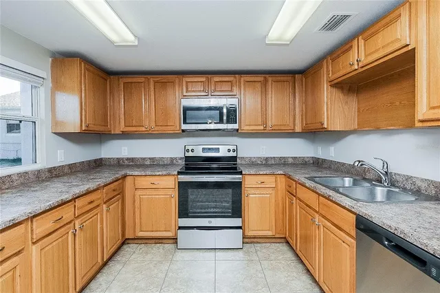 a kitchen with stainless steel appliances granite countertop a sink stove and cabinets