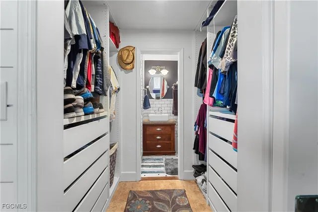 a view of walk in closet with clothes and shoes