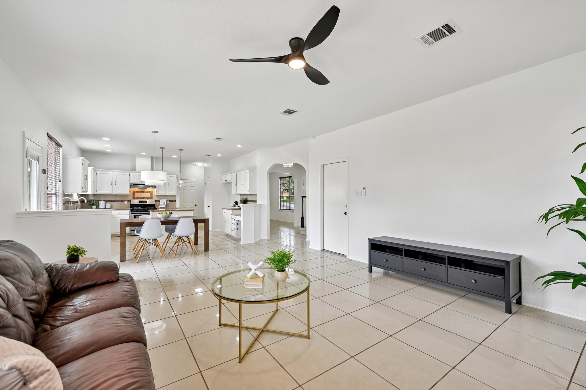 4100 Mocha Trail Austin, TX 78728 - Photo 33 of 33 An open floorplan features gleaming tile floors and a chic ceiling fan, seamlessly connecting living and dining areas.