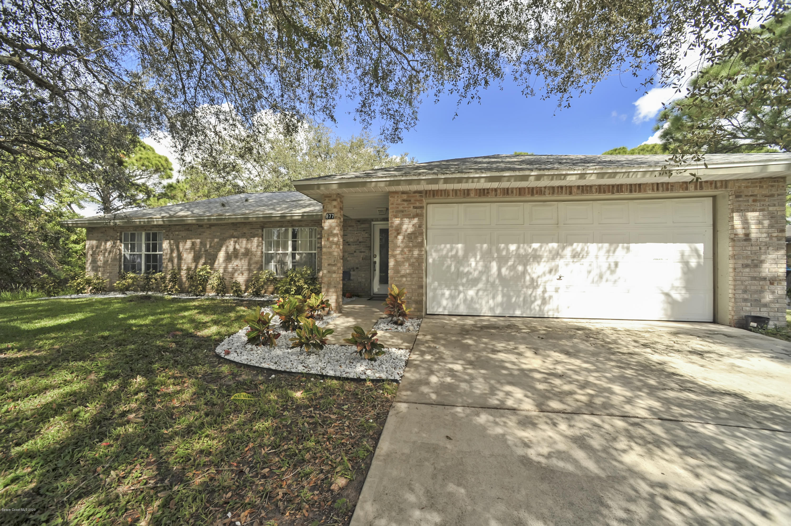 877 Walpole Road Southwest Palm Bay, FL 32908 - Photo 1 of 27 a front view of a house with garden