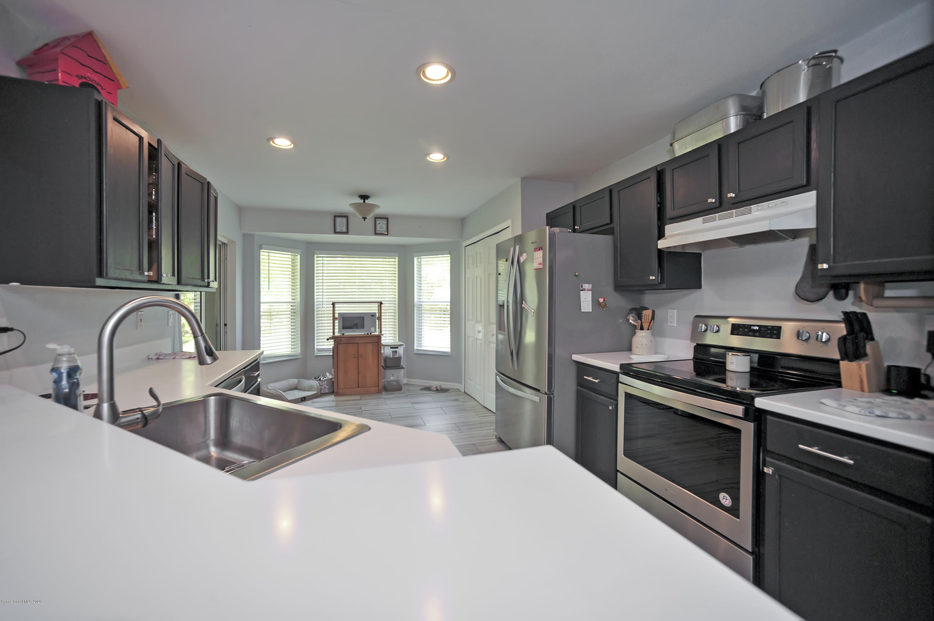 877 Walpole Road Southwest Palm Bay, FL 32908 - Photo 13 of 27 a kitchen with stainless steel appliances granite countertop a sink stove and refrigerator
