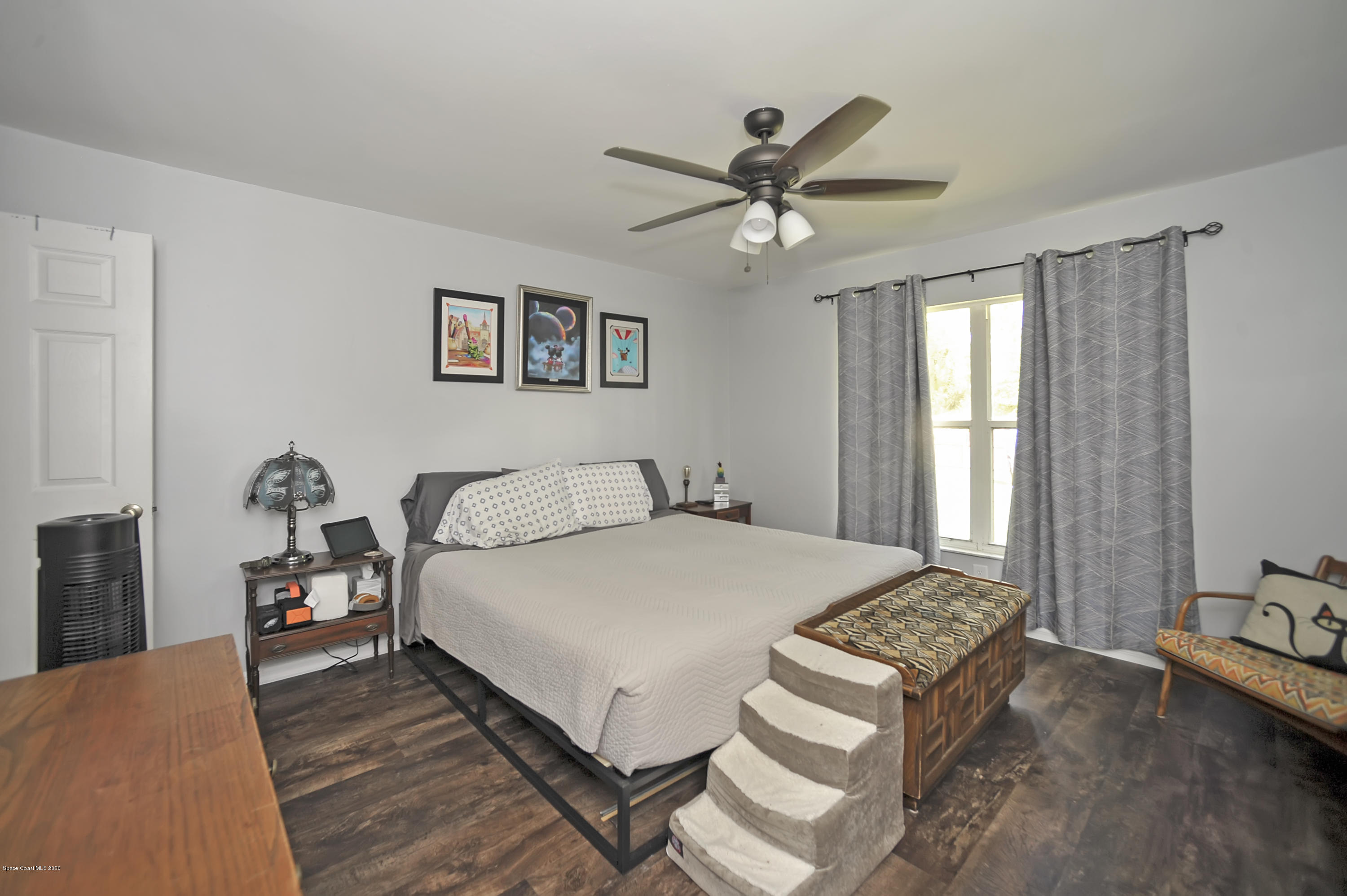 877 Walpole Road Southwest Palm Bay, FL 32908 - Photo 16 of 27 a bedroom with a bed and a chandelier