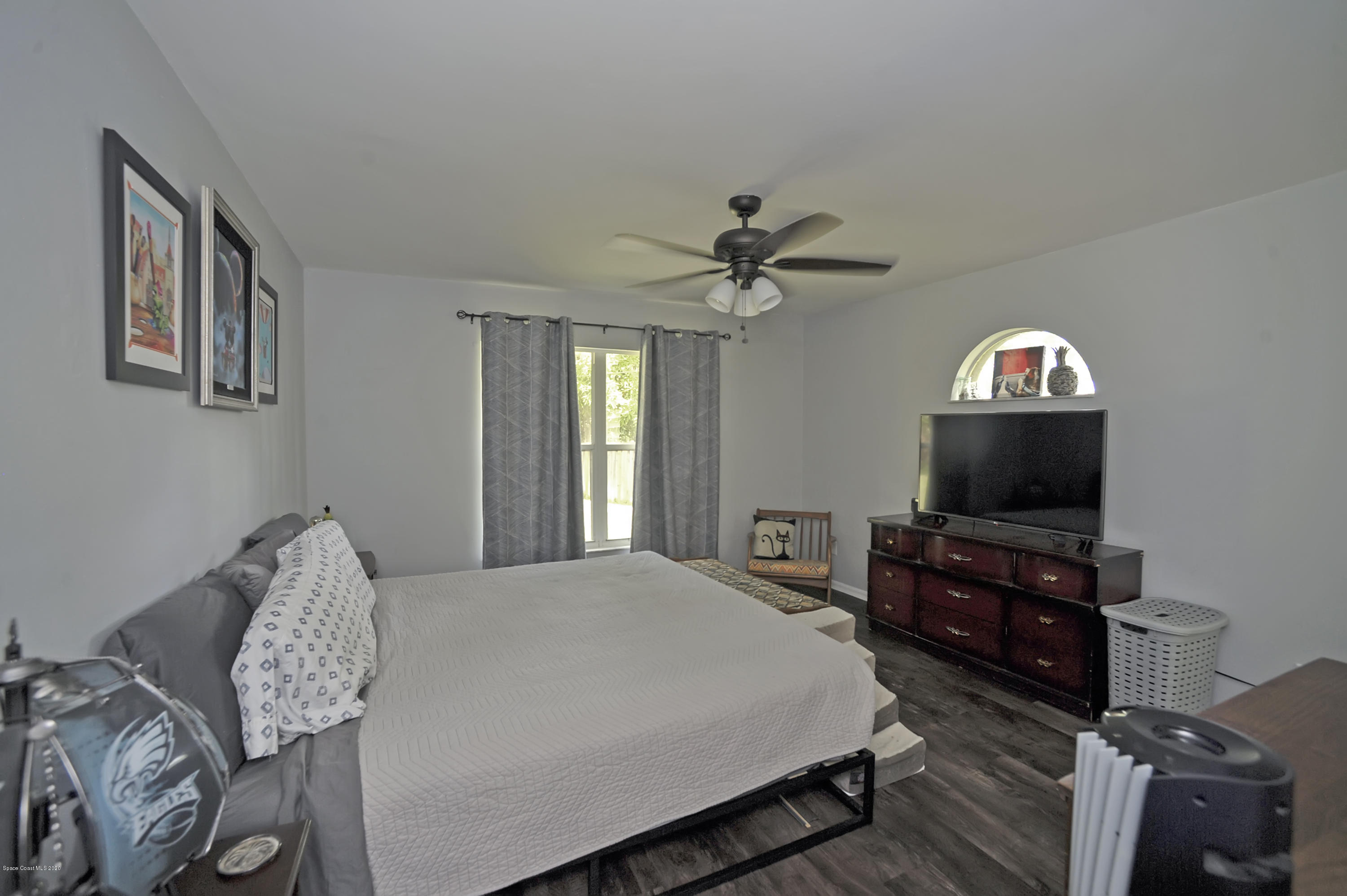 877 Walpole Road Southwest Palm Bay, FL 32908 - Photo 17 of 27 a bedroom with a bed and a mirror on dresser